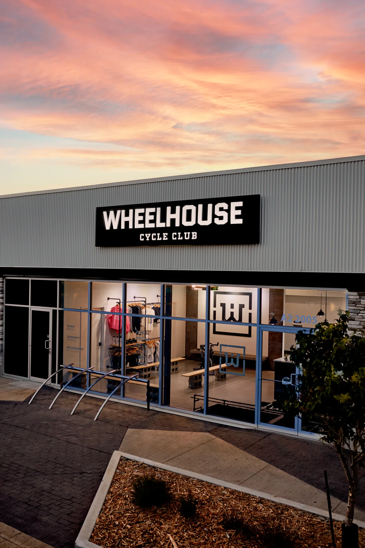 Wheelhouse Cycle Club’s signed entrance at sunset, with the front doors and Unit A2 visible